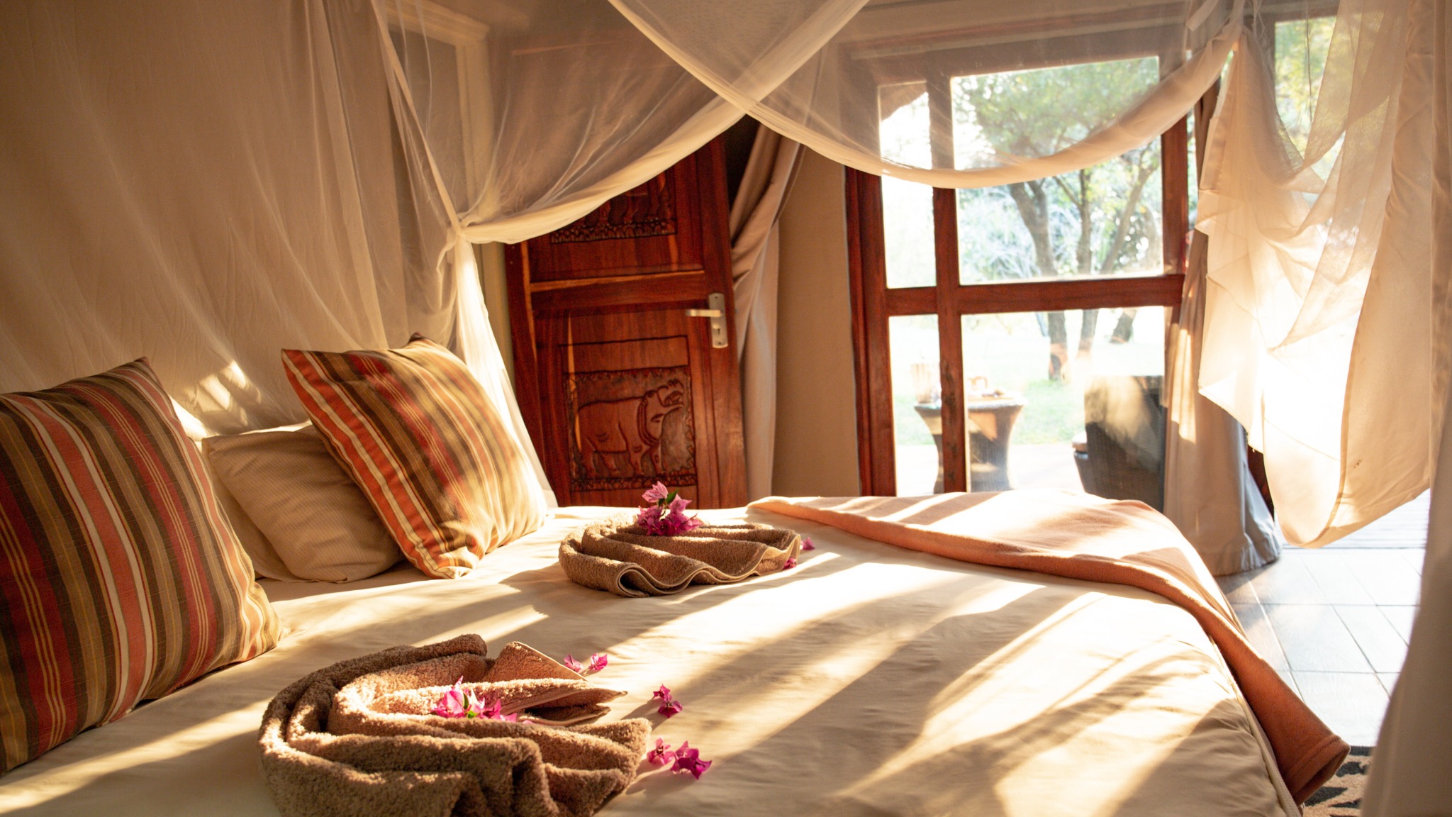 Sunlit double bed beside a chalet window